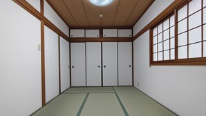 Ein traditioneller japanischer Raum mit Tatami-Boden, Schiebetüren und einem Shoji-Bildschirm.