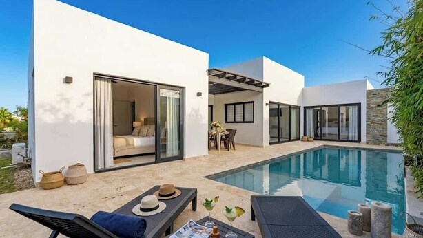 A modern house with a swimming pool, outdoor seating, and a patio area. - Private Pool Villa in Sosua's Ocean Village (Sosúa)