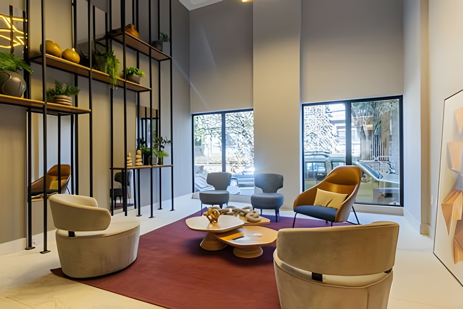 Un interior moderno con techo alto, alfombra roja y una mezcla de mobiliario contemporáneo.