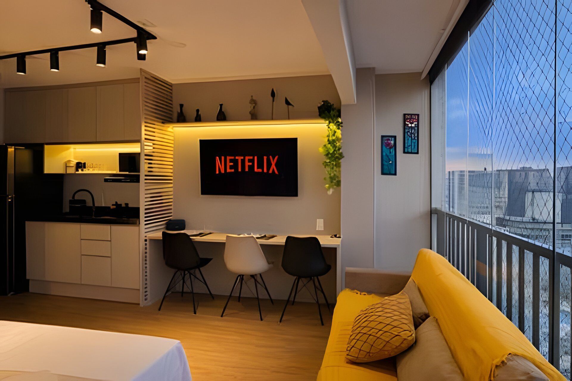 A modern apartment with a kitchen, dining area, and a living room with a yellow sofa.