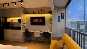A modern apartment with a kitchen, dining area, and a living room with a yellow sofa.