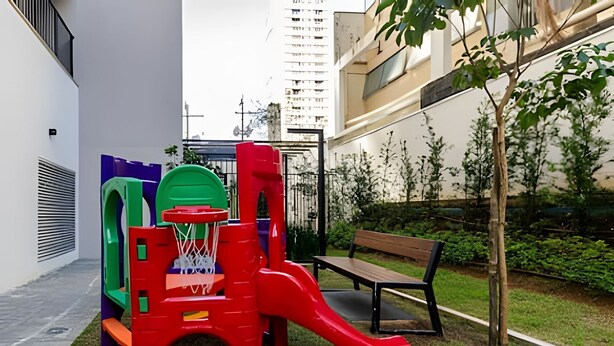 A playground with a slide and climbing structures, a bench, and a small tree in an urban setting. - Smart Bourbon 2009 (São Paulo)