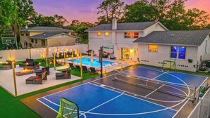 A residential property with a swimming pool, outdoor seating, and a basketball court. - GAME ON! Heated Pool, Pickleball, Outdoor Theater! (Seminole)