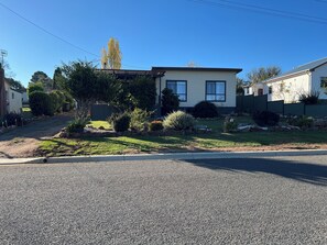 Un barrio residencial con casas, una calle pavimentada y cielo despejado.
