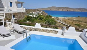 A pool area with a view of the sea and a mountainous landscape. - Panormos Retreat With Pool (Mykonos)