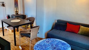 Een gezellige zithoek met een ronde tafel, een bank en twee stoelen.