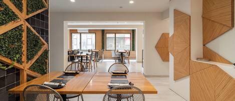 A modern conference room with a long table, chairs, and a view of the city through large windows.