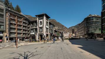 Un hotel con fachada tradicional, una torre central y un edificio moderno a la derecha.