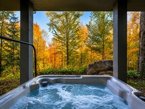 A hot tub with a view of autumn trees. - Chalet du Sommet SPA (Sainte-Béatrix)