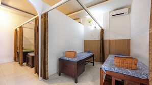 Ein Zimmer mit einem Bett, einem kleinen Tisch mit einem Korb, einer Bank und einer Wandklimaanlage.