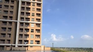 Una piscina con dos aros naranjas, una terraza de madera y un edificio alto al fondo.