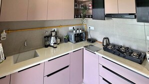 Una cocina moderna con estufa a gas, cafetera y horno empotrado.