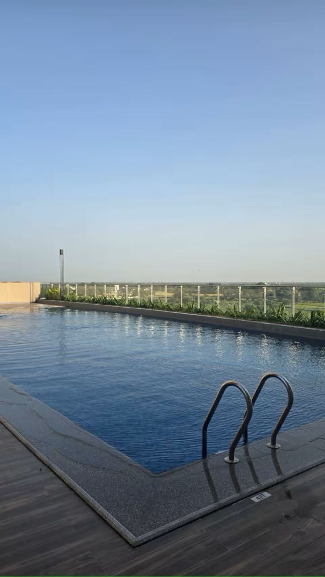 A rooftop swimming pool with a clear view of the cityscape in the background.