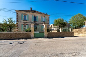 A two-story building with a stone facade, green shutters, and a gated entrance. - Le Saint Laurent - Avec Piscine Privée (Saint-Laurent-la-Vernède)