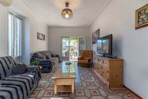 A living room with a sofa, a coffee table, a TV, and a wooden cabinet. - Le Saint Laurent - Avec Piscine Privée (Saint-Laurent-la-Vernède)