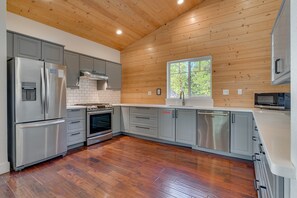A modern kitchen with stainless steel appliances, grey cabinets, and a wooden ceiling. - Cozy Mountain Retreat w/ Spacious Living Spaces | Fireplace | Modern Kitchen | Deck: Modern Pines (South Lake Tahoe)