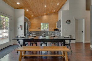A modern kitchen with wooden ceiling, a dining table set for four, and a visible fire extinguisher. - Cozy Mountain Retreat w/ Spacious Living Spaces | Fireplace | Modern Kitchen | Deck: Modern Pines (South Lake Tahoe)