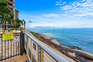 A beachfront hotel with a pool area closed sign, a lifeguard tower, and a view of the ocean. - Oceanfront Ground-Level Luxe Getaway West Maui (Lahaina)