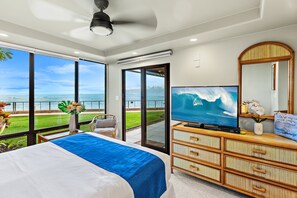 A bedroom with a large bed, a television, a dresser, and a view of the ocean. - Oceanfront Ground-Level Luxe Getaway West Maui (Lahaina)
