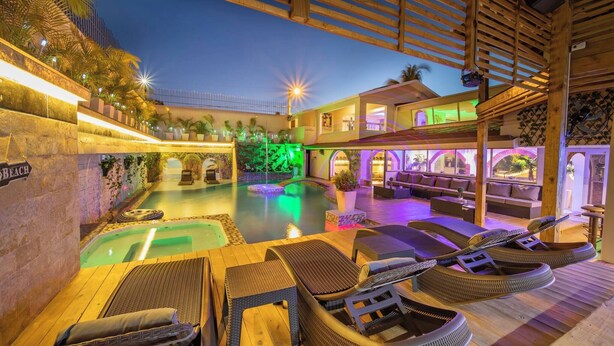 A pool area with lounge chairs and a bar. - Luxury 6 Bedroom Villa in Sosua Beachfront Bliss Awaits (Sosúa)