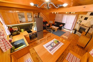 A cozy cabin interior with a kitchen, dining area, and living space. - Relax by the Mrežnica River with jacuzzi, sauna and forest view (Mihalić Selo)