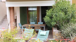 A patio with a table and chairs, a staircase, and a garden with various plants.