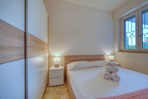 Une chambre à coucher avec un lit, des tables de chevet et une fenêtre.