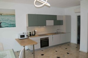 Een moderne keuken met een inbouwoven, magnetron en spoelbak.