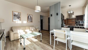 Un salon moderne avec un canapé, une table basse en verre et un coin repas avec des chaises.
