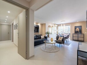A modern living room with a sofa, armchairs, a coffee table, and a dining area with chairs. - 2-Br Apartment – Terrace, Cannes City Centre (Cannes)