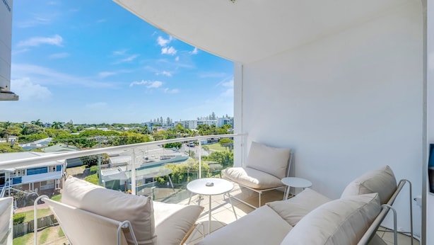 A balcony with a view of a cityscape, including a highway and buildings. - Platinum Apartments -  Unit 22 (Bargara)