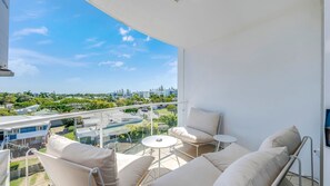 A balcony with a view of a cityscape, including a highway and buildings.