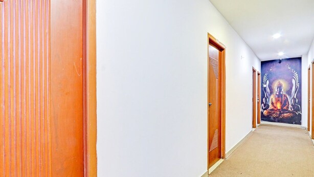 A hallway with wooden doors and a mural of a meditating figure.