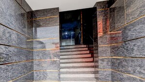 A staircase with marble walls and golden lines, leading to a dark interior. - Saver Double Hotel Admire Suit (Chennai)