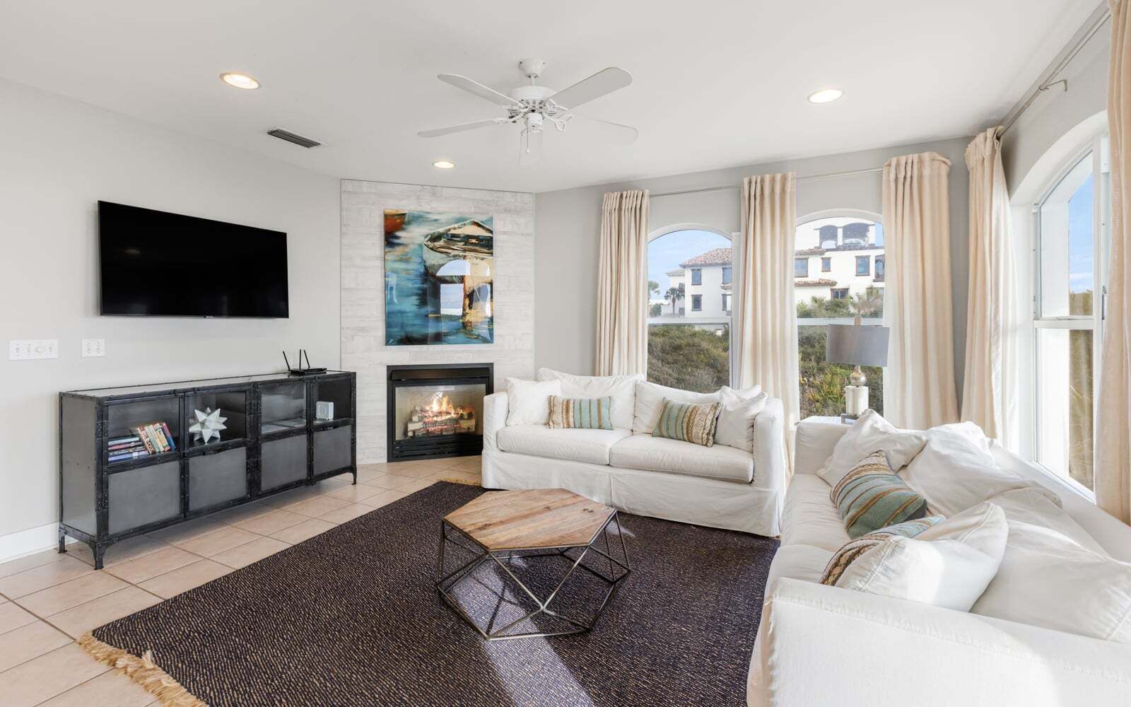 A modern living room with a fireplace, a flat-screen TV, a sofa, and a coffee table.