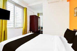 A hotel room with a bed, a wardrobe, a television, and a window with curtains. - Deluxe Super Collection O Banaswadi (Bengaluru)
