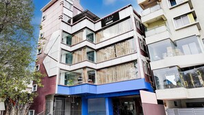 A multi-story building with a modern architectural design, featuring balconies and large windows. - Deluxe Super Collection O Banaswadi (Bengaluru)