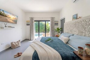 Un dormitorio con cama, vistas al exterior, televisión y un cartel en la pared.