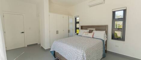 A bedroom with a bed, wardrobe, and a window.