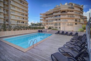 A rooftop swimming pool with lounge chairs and a view of multi-story buildings. - Upstays charming t2 renovated balcony and  pool (Cannes)