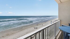 Un balcon avec vue sur une plage et l’océan.