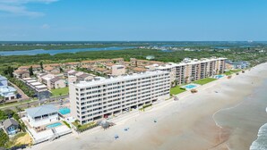 Un hôtel en bord de mer composé de plusieurs bâtiments, doté d’une piscine et donnant accès à une plage.