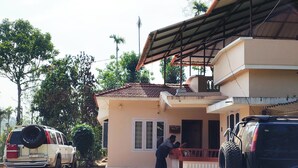 A two-story building with a flat roof and a porch.