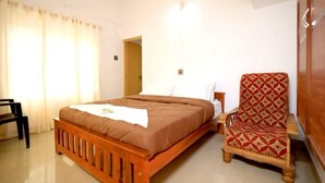A bedroom with a wooden bed, a chair, a wardrobe, and a door leading to another room.