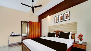 Un dormitorio con una cama, una mesita de noche, un ventilador de techo y una obra de arte en la pared.