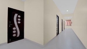 Un pasillo con un diseño de puerta moderno, pared de color claro e iluminación empotrada en el techo.