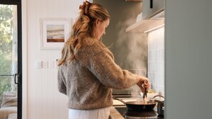 Una persona cocina en una cocina moderna con vistas al exterior.