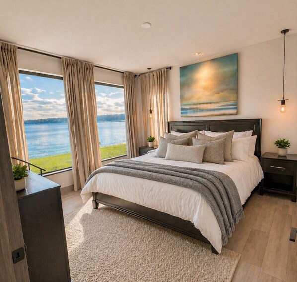 A bedroom with a large bed, a view of the lake, and a painting on the wall. - Beachfront I Hot Tub | EV Charger | Fire Pit (Clinton)
