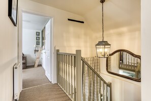 Eine Treppe mit Handlauf, einer Lampe und einem Spiegel.