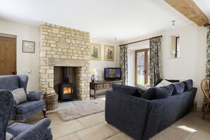 A cozy living room with a stone fireplace, comfortable seating, and a television. - Norton Subedge Barn -  Mickleton, Chipping Campden sleeps 6 guests (Mickleton)